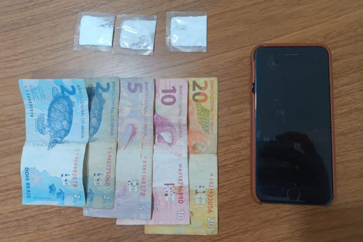 Dinheiro, entorpecentes e celular apreendidos
