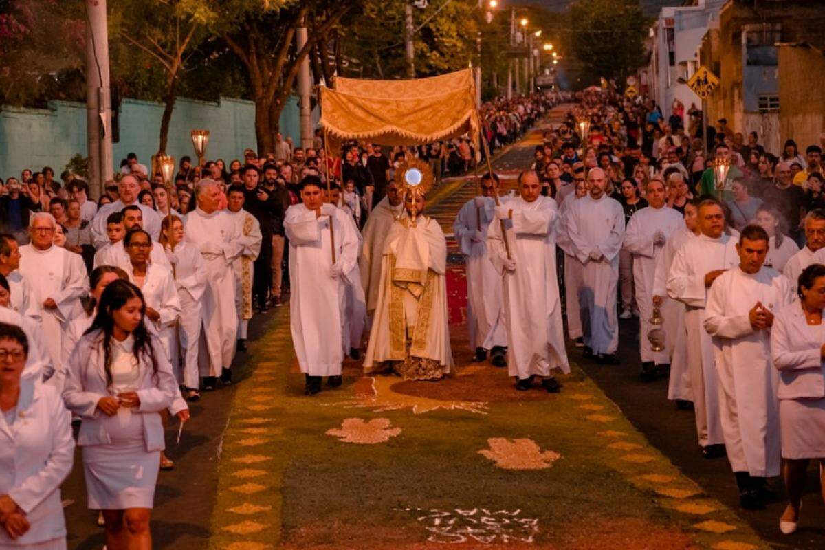 Fiéis confeccionam tapetes coloridos com serragem e outros materiais, simbolizando passagens bíblicas durante a celebração de Corpus Christi em Jundiaí