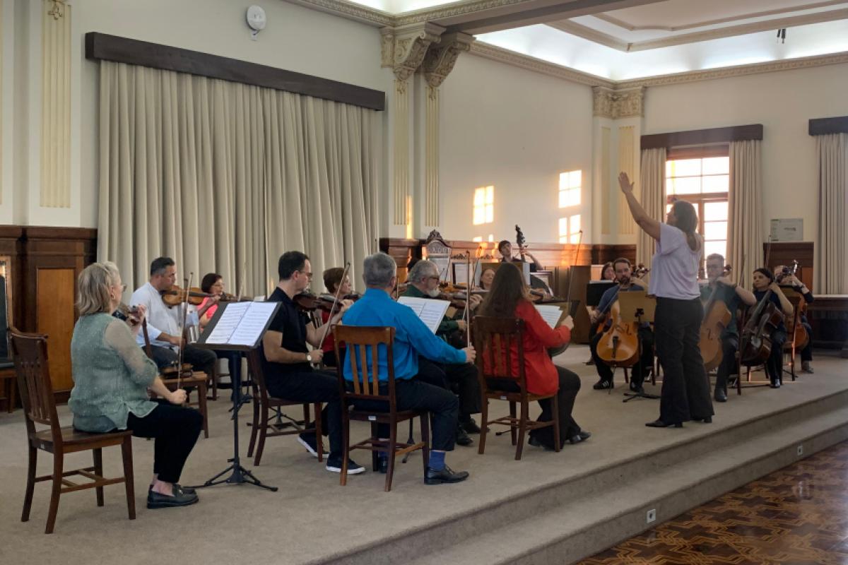Sob a direção artística da maestrina Gretchen Miller, o grupo reuniu músicos amadores e profissionais em uma formação auto-gerida, e se apresentam regularmente