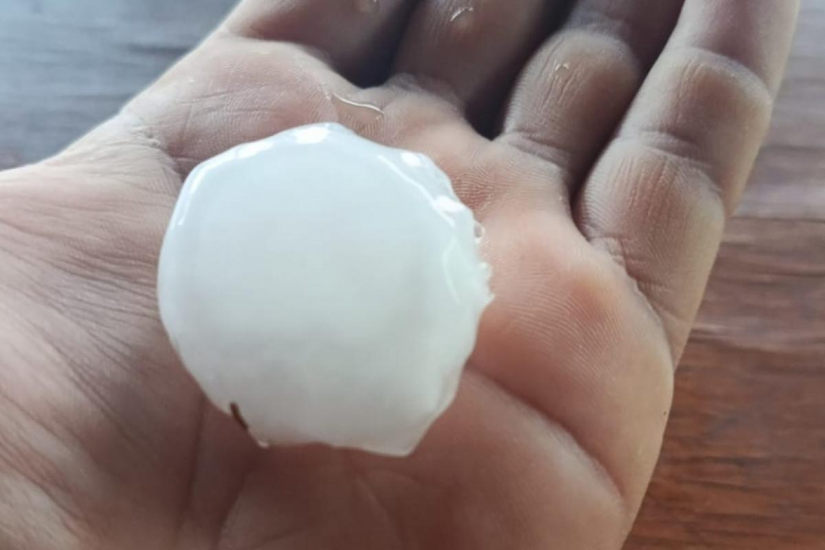 Moradora segurando uma pedra de gelo que caiu em Claraval