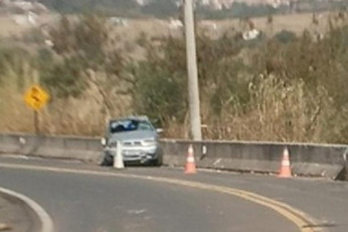 O carro ficou destruído após bater na mureta da rodovia.
