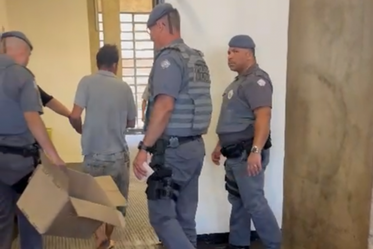 Homem sendo apresentado ao delegado após ser preso pela Polícia Militar