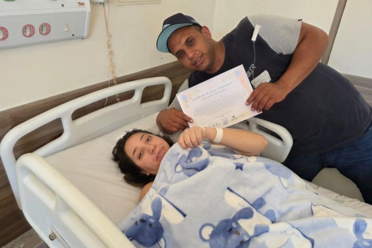 Helen e o marido Felipe com o certificado de doação da placenta para pesquisa científica 