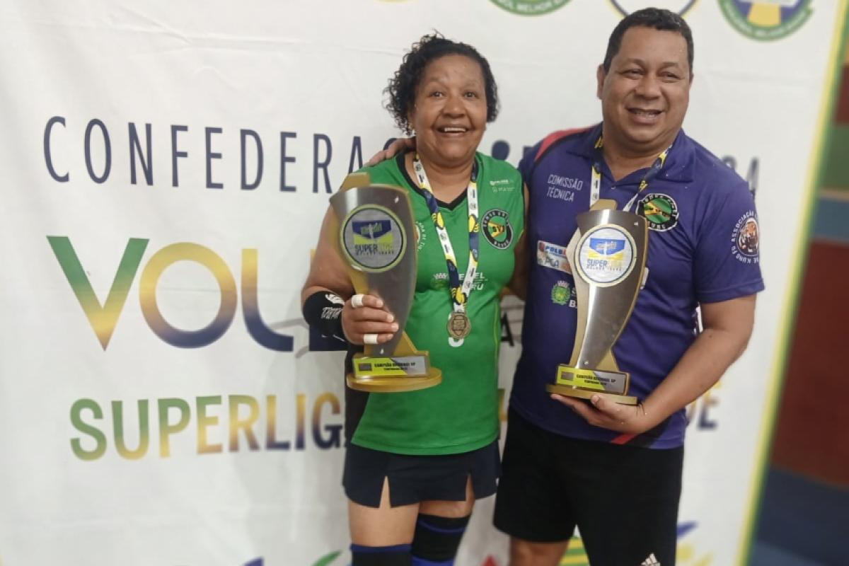 Jogadora Erô e técnico Carlos Lenta com troféus da semana passada