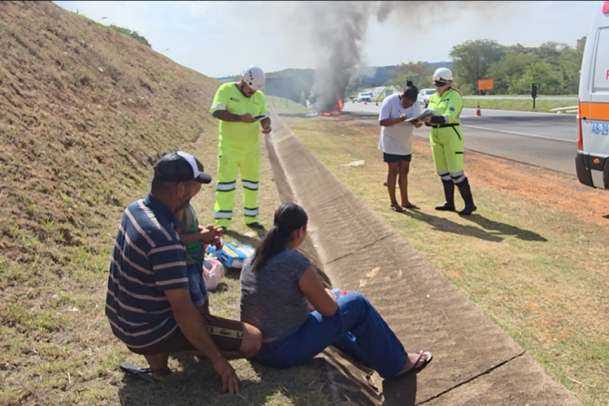 Momento em que a Kombi pega fogo na rodovia; família foi atendida por funcionários da concessionária 