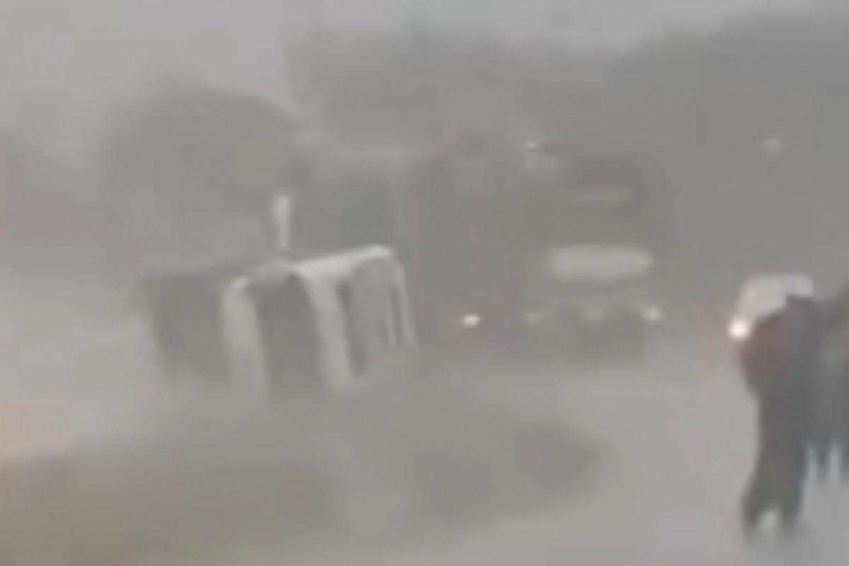 Com o forte impacto, um dos caminhões tombou na pista de rolamento. 