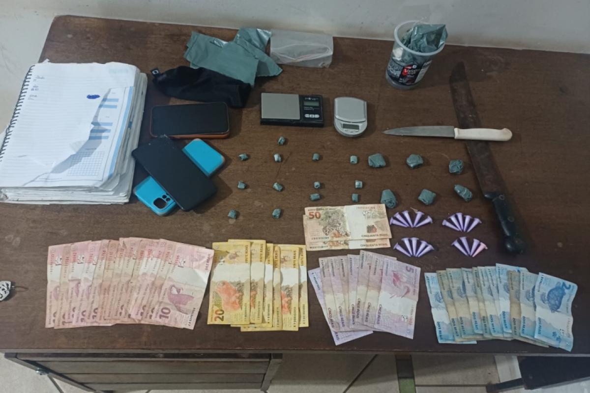 Dinheiro, entorpecentes e apetrechos para o tráfico apreendidos pela polícia
