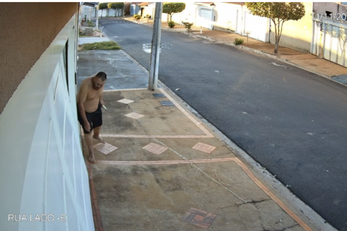 Carlos Henrique Costa Pimenta tentando levantar o portão da casa da irmã de sua ex-companheira 