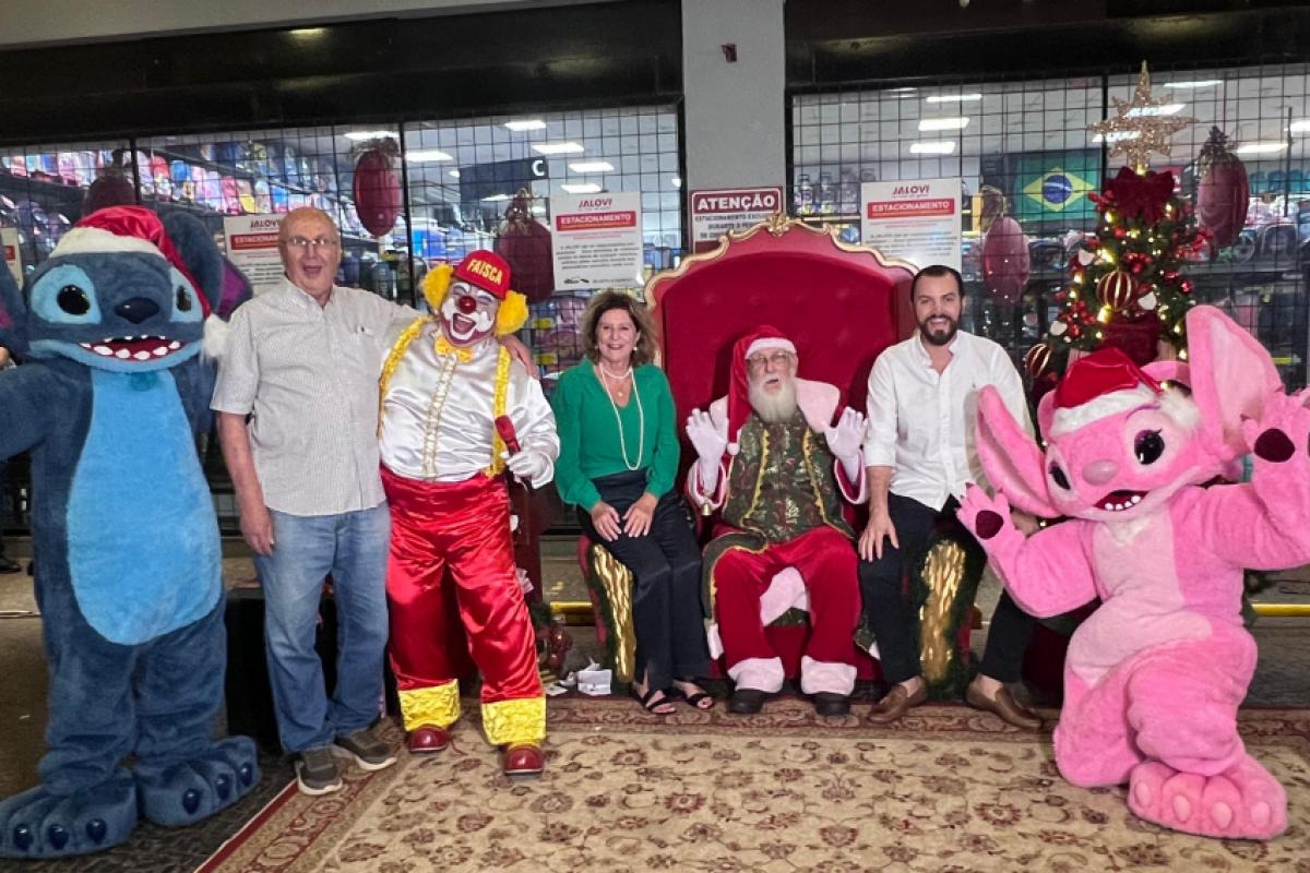 Jair, Eliane e Gabriel Lot Vieira com o Papai Noel, palhaço Faísca e os personagens Stitch e Angel