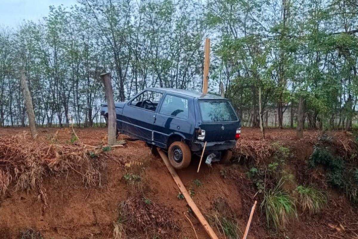 Carro abandonado às margens da rodovia Tancredo Neves, pendurado em barranco