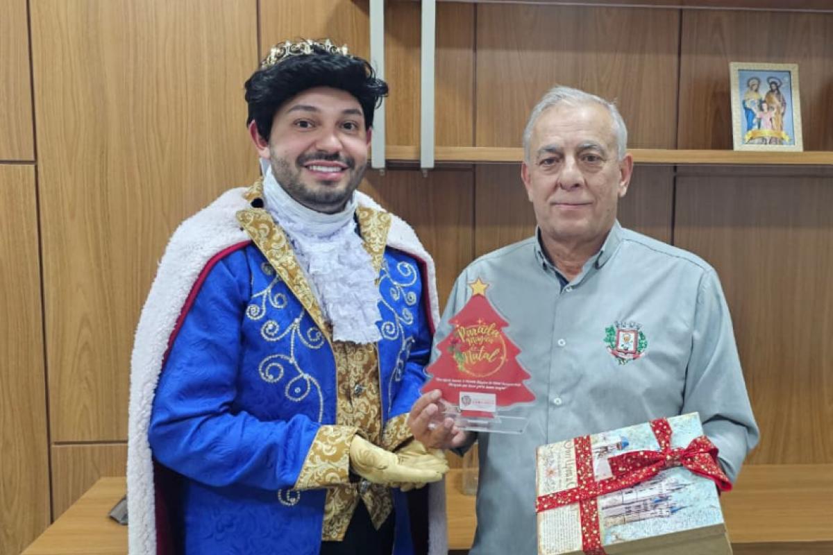 Idealizador e príncipe Fabrício entrega o convite da Parada Mágica de Natal ao prefeito Chéco; gesto simbólico que marca a abertura das celebrações em Coroados