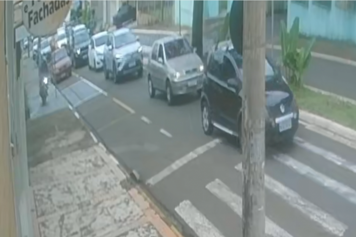 Motociclista 'cortando fila' pela calçada, ates de bater contra carro estacionado. 