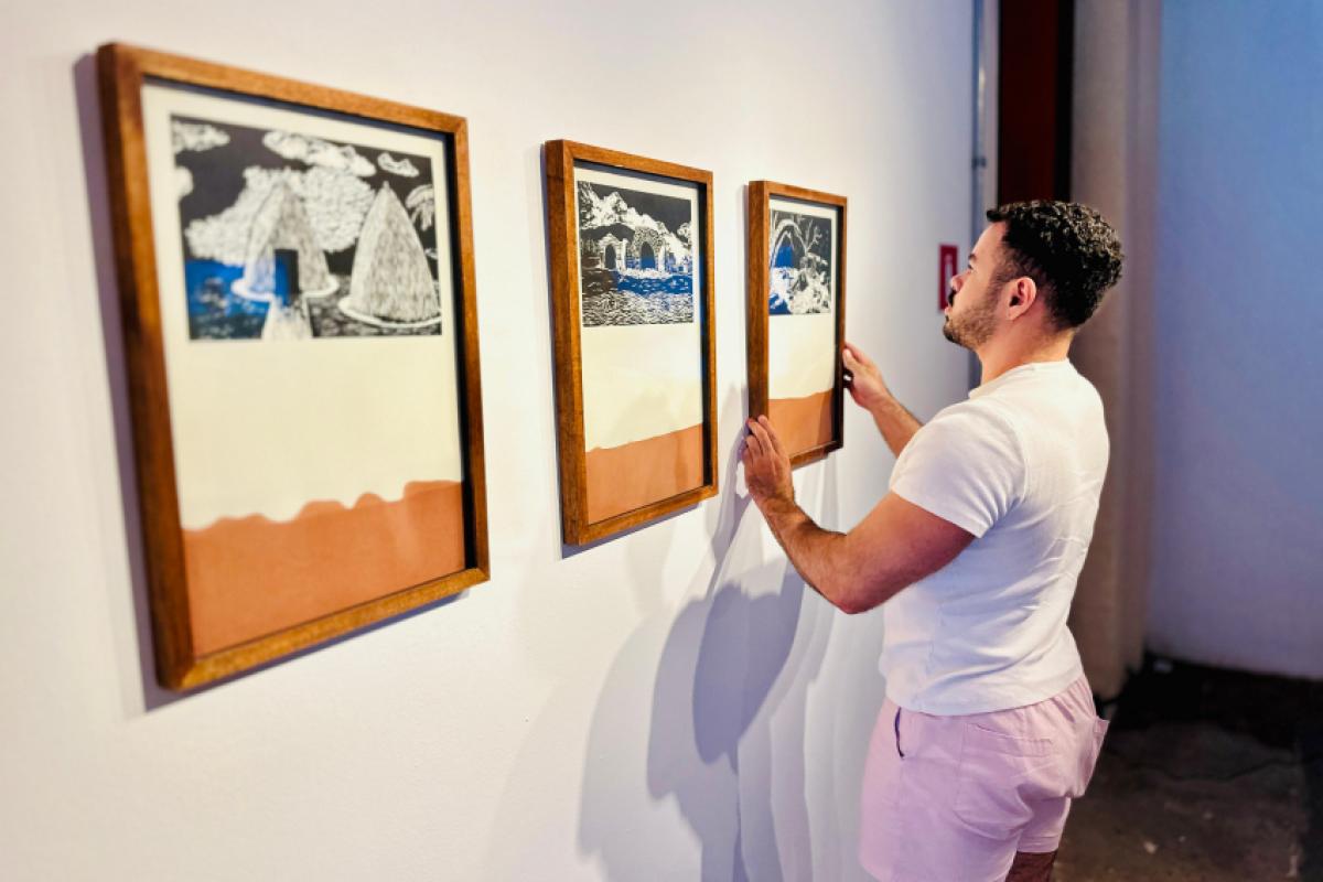 Fernando Oliveira, curador da mostra, posiciona um dos quadros que estarão expostos no 54º SAC.