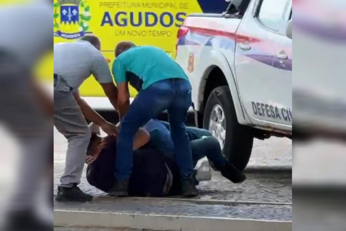 Dois homens brigando e dos apartando a luta na Praça Tiradentes