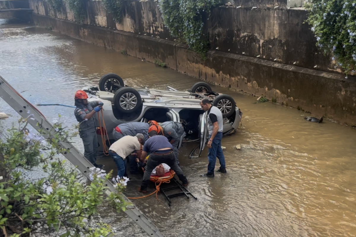 Corpo de Bombeiros retirando idoso de dentro do carro após cair no córrego Cubatão, em Franca