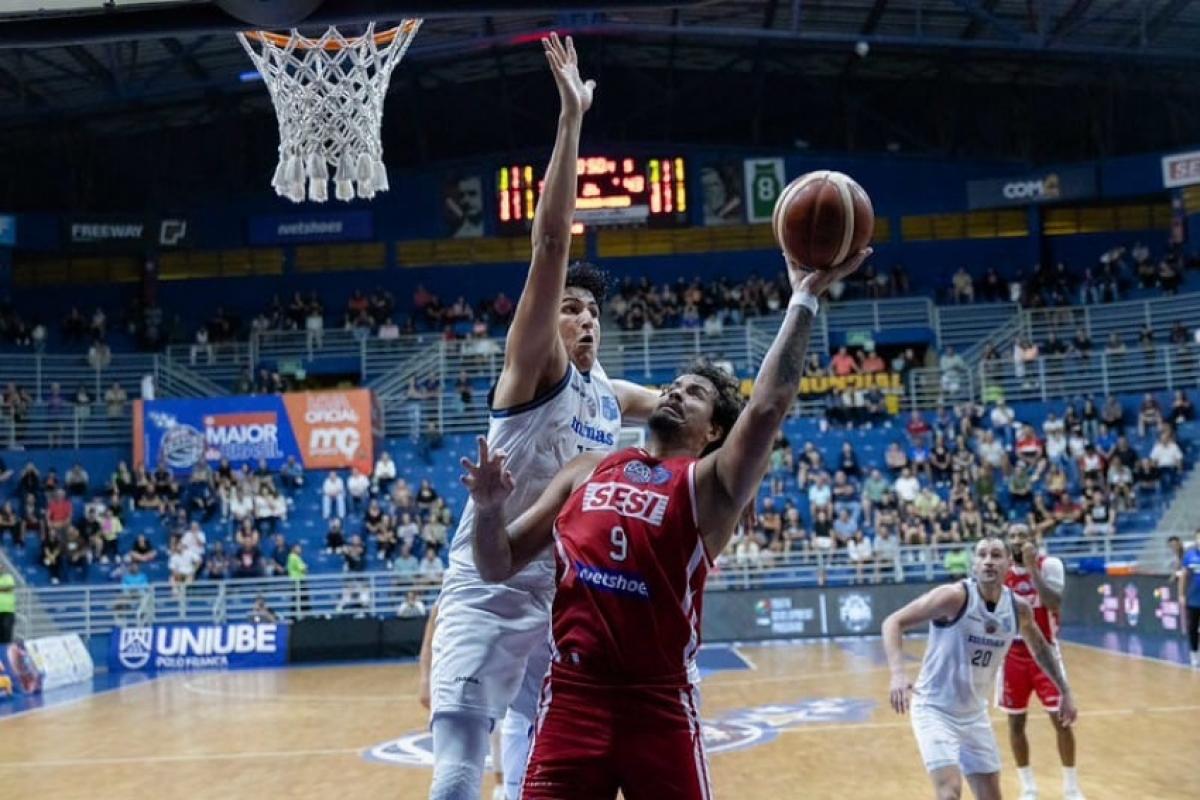 Lucas Dias rumo à cesta enquanto é marcado por adversário