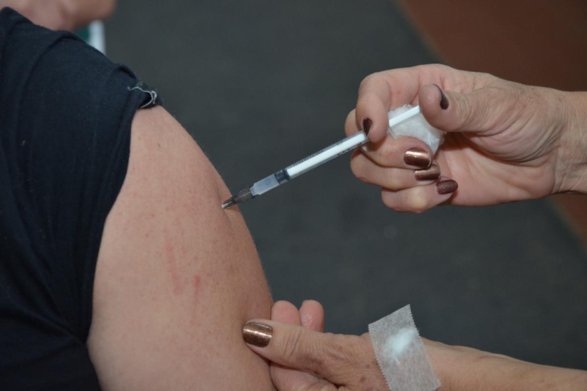 Mulher recebendo imunização; vacinação acontece nas UBSs 