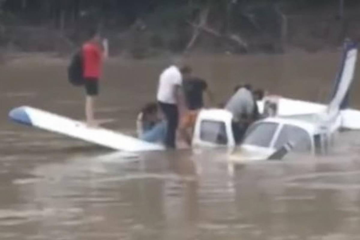 Um vídeo feito por um morador mostra o avião parcialmente encoberto pela água, com passageiros em cima da aeronave