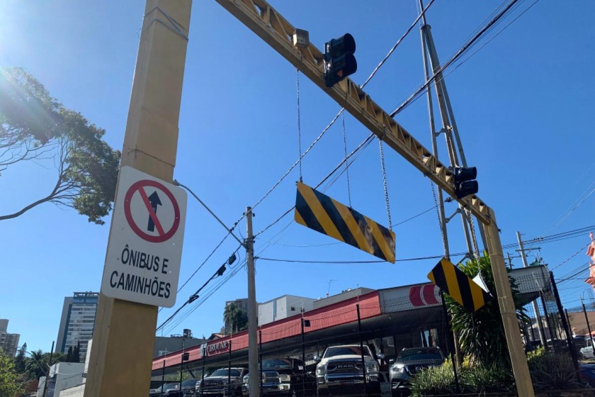 Uma das correntes responsáveis por fixar a placa ficou pendurada após o impacto, chamando a atenção de comerciantes e de pessoas que circulam pela região