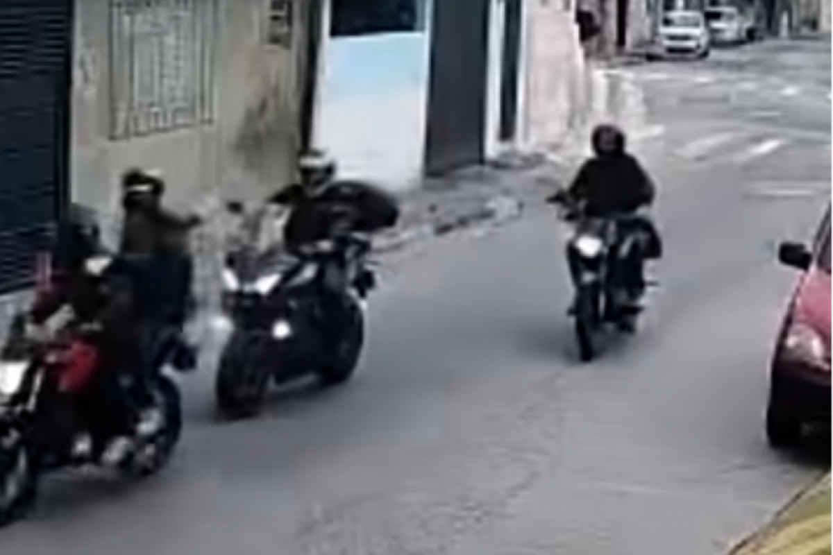  As imagens mostram que três suspeitos em duas motos abordam o guarda.