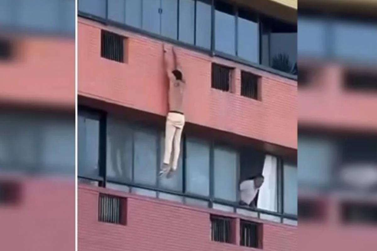 Imagens feitas por testemunhas mostram a vítima do lado externo do prédio, tentando alcançar a estrutura do andar inferior. 